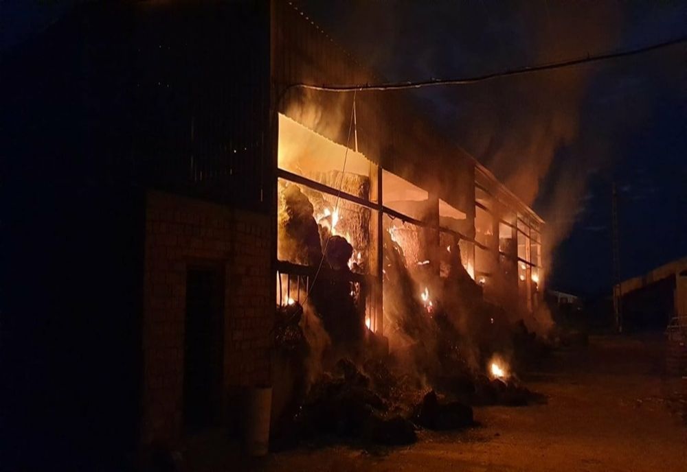 Depozit de fân mistuit de flăcări